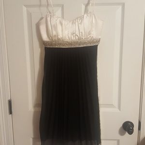 A sperchless black and white dress with straps.